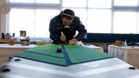 Рабочий обрабатывает край зелёного сап-борда